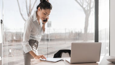 Asian businesswoman on the phone and using digital tablet